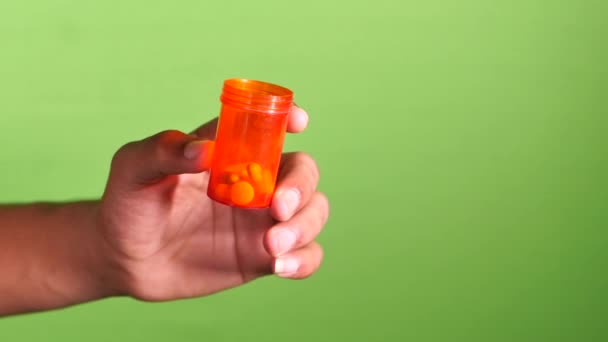 Gros plan de l'homme main tenant récipient pilule sur écran vert — Video