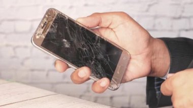 Kırık akıllı telefonu tutan adama yakın dur..