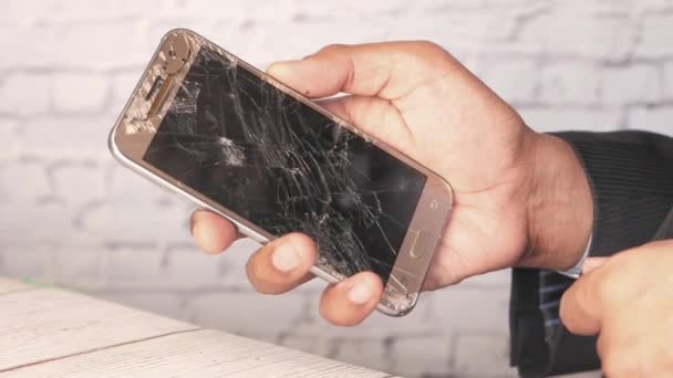 Gros plan de l'homme main tenant téléphone intelligent cassé. — Video