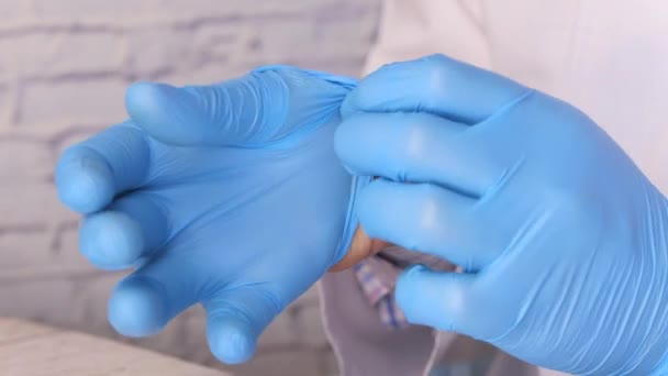 Доктор носит медицинские перчатки, крупным планом — стоковое видео