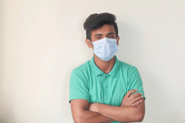 Een jonge man met een beschermend masker tegen een muur — Stockfoto