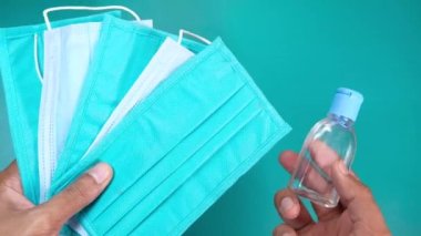  Adamın elinde cerrahi maske ve dezenfektan jeli var. 