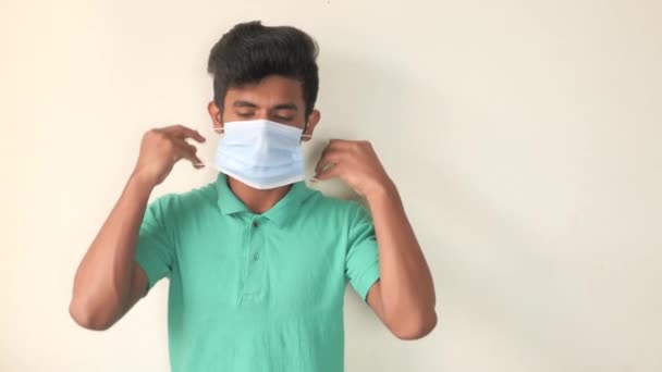 Ein junger Mann mit Schutzmaske gegen eine Wand — Stockvideo