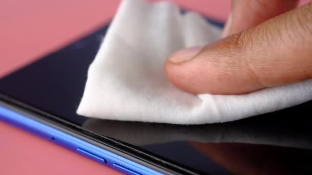 ウイルスを防ぐために携帯電話のディスプレイを掃除する男 — ストック動画