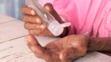 Virüsü önlemek için dezenfektan jeli kullanan yaşlı kadınların ellerini kapatın 