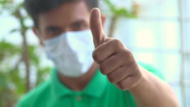  Genç adam dışarıda baş parmağını kaldırıyor. 