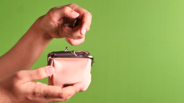 Kvinnor hand spara mynt i en väska på grön skärm — Stockvideo