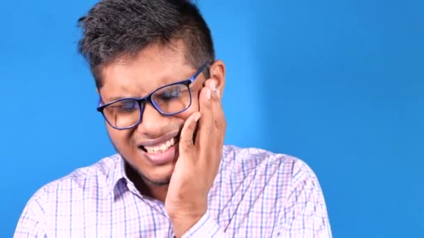 Junger Mann mit empfindlichen Zähnen auf blauem Hintergrund — Stockvideo