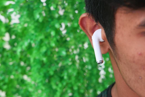 Young man putting wireless hear phone close up — Stock Photo, Image