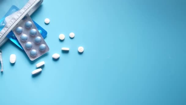 Vista dall'alto di pillole versando su sfondo blu — Video Stock