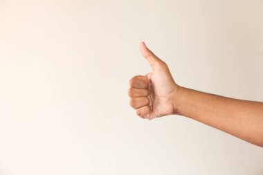 Adamın eli beyaz duvarda baş parmak gösteriyor. 