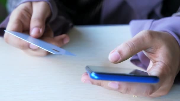 Kadınlar ellerinde kredi kartıyla internet üzerinden akıllı telefon alışverişi yapıyorlar. — Stok video
