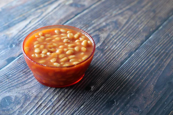 Ahşap arka planda bir kasede lezzetli fasulyeler. ,