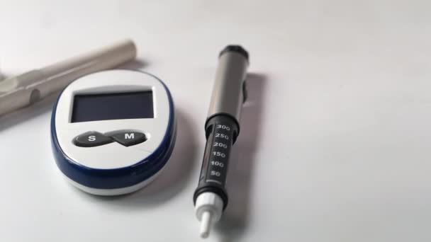 Діабетичні засоби вимірювання та інсулінова ручка на столі — стокове відео