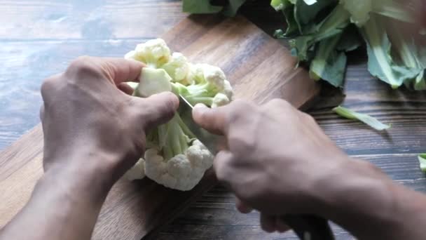 Visão traseira do homem cortando couve-flor na tábua de corte — Vídeo de Stock