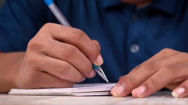 Κοντινό πλάνο του ανθρώπου χέρι γράφοντας στο σημειωματάριο. — Αρχείο Βίντεο