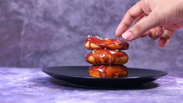 Mão escolher donuts de chocolate no prato — Vídeo de Stock