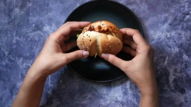 Masanın üstünde el ele tutuşan sığır burger. 