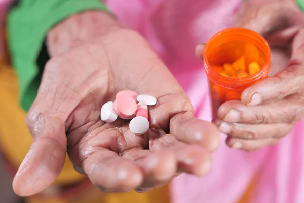 senior women hands taking medicine, close up