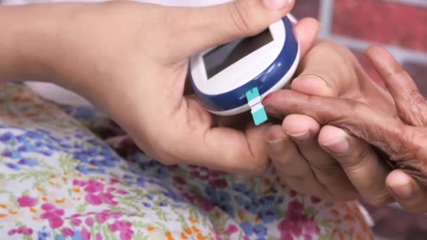 Lekarz prowadzący badanie stężenia cukru we krwi starszych kobiet — Wideo stockowe
