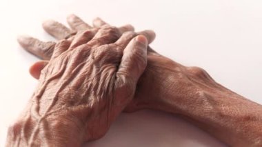 Yaşlı kadınlar beyaz arka planda ellerine dokunuyor. 