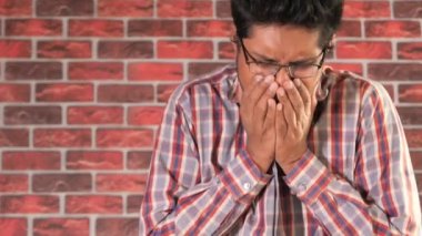  Genç Asyalı adam öksürüyor ve hapşırıyor. 