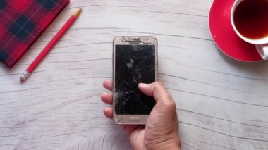 Kırık akıllı telefonu tutan adama yakın dur..