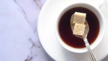 Bir fincan çay ve kahverengi şeker.