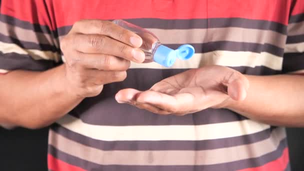 Virüsü önlemek için dezenfektan jel kullanarak genç adamın elini kapat. — Stok video
