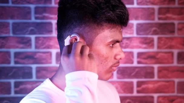 Concepto de audífono, un joven con problemas auditivos. — Vídeos de Stock