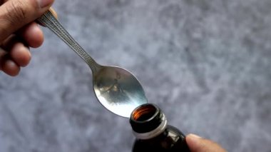 Bir kaşık üstüne sıvı ilaç dökülüyor. 