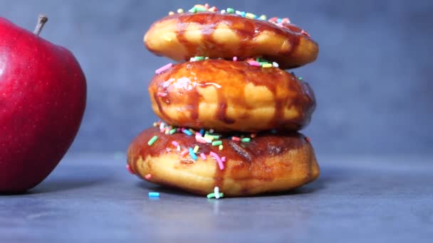 Pilha de donuts de chocolate e maçã na mesa — Vídeo de Stock