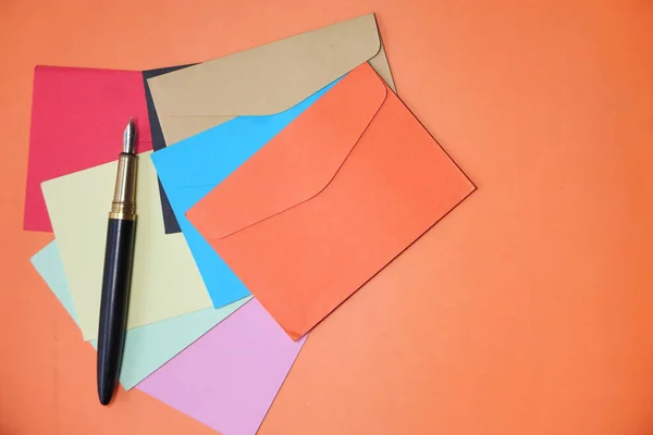 Envelope colorido no fundo laranja com espaço de cópia. — Fotografia de Stock