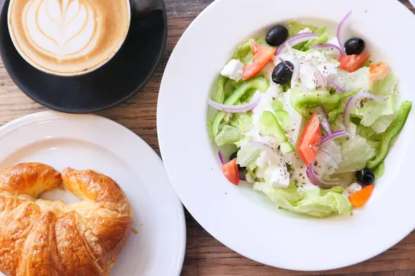 Primer plano de ensalada griega y café en la mesa —  Fotos de Stock