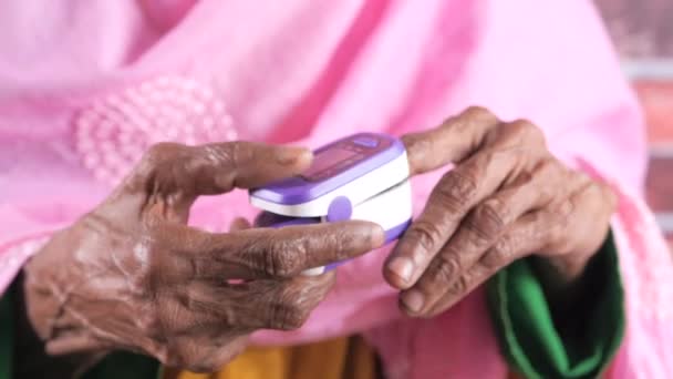 Senior vrouwen hand met behulp van pulse oximeter — Stockvideo