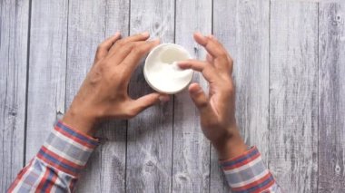 Kadın ev manzarasında cildine güzellik kremi sürüyor. 