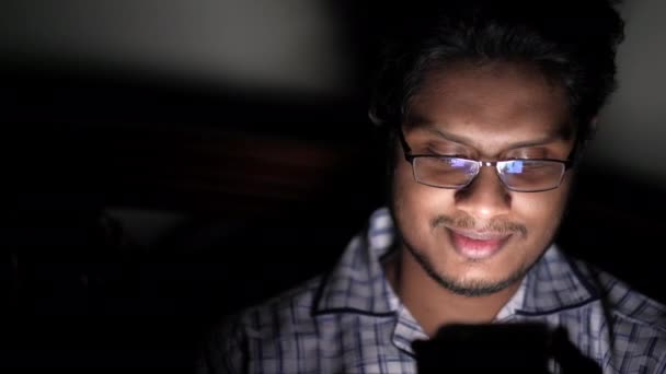 Hombre joven usando el teléfono inteligente en la noche — Vídeo de stock