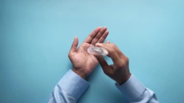 Mavi sırt çantasındaki virüsü önlemek için dezenfektan jeli kullanan bir adam. 