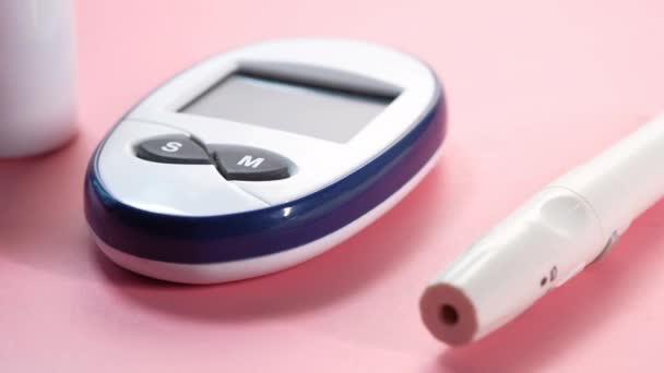 Діабетичні засоби вимірювання та інсулінова ручка на рожевому — стокове відео