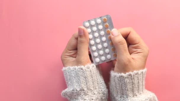 Mujeres mano golding píldoras anticonceptivas de cerca — Vídeos de Stock