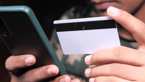 Hombre mano celebración de la tarjeta de crédito y el uso de compras de teléfonos inteligentes en línea — Vídeo de stock