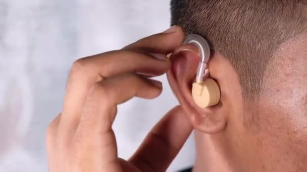 Hearing aid concept, a young man with hearing problems. — Stock Video