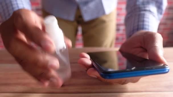 Homem mão desinfectando a tela do telefone inteligente com higienizar — Vídeo de Stock