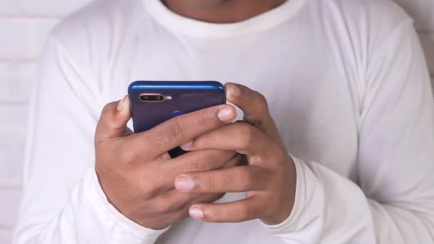 Jovem em vestido casual usando telefone inteligente. — Vídeo de Stock