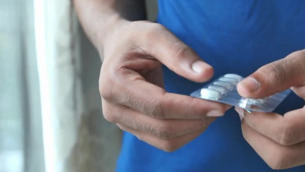ブリスターパックから薬を飲んでる若い男の近くに — ストック動画