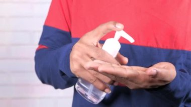 Virüsü önlemek için dezenfektan jel kullanarak genç adamın elini kapat. 