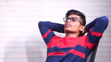  Üzgün genç adam bir sandalyede tek başına oturuyor. 