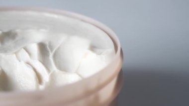 Yüz kremini beyaz arkaplanda bir kapta kapat