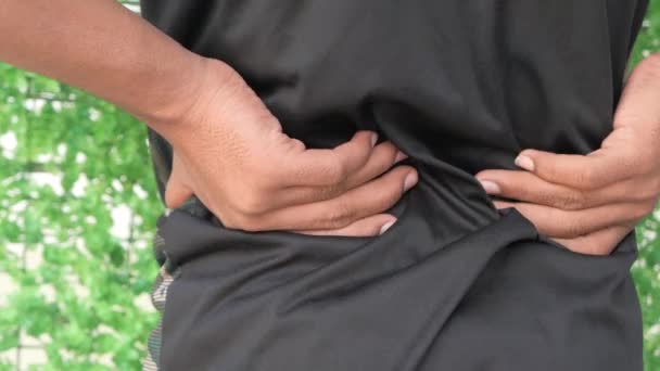 Молодой человек, страдающий от боли в спине — стоковое видео