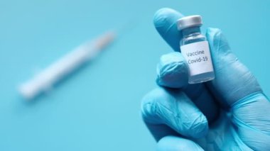 Doktor elinde koronavirüs aşısı olan eldivenleri teslim et.